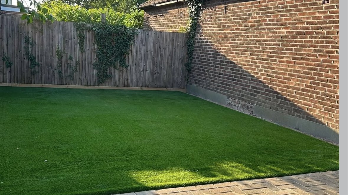 Herringbone block paving meeting a newly laid artificial grass lawn